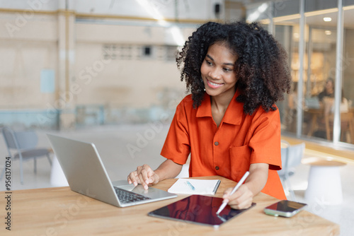 About successful young woman concept. Excited African American woman sitting at working desk.