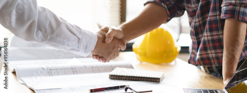 Client shaking hands with contractor after confirm blueprint to renovate house. photo