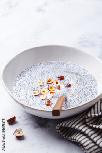 Chia pudding with hazelnuts and maple syrup, white background. photo