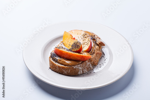 Peanut butter toast with peach and seeds.