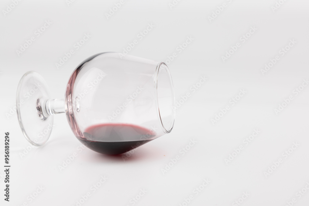 Subtle Wine Glass Leaning on Body with a Hint of Red Wine in Horizontal Layout with White Background Subtle Wine Glass Leaning on Body with a Hint of Red Wine in Horizontal Layout with White Background