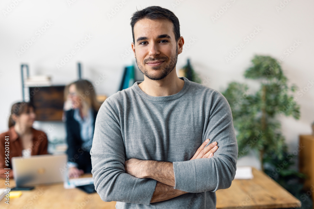Smiling businessman with arms crossed in office Smiling businessman with arms crossed in office