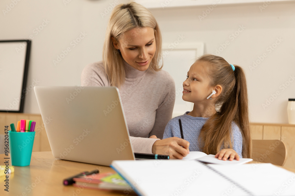 Girl doing homework with mother at home Girl doing homework with mother at home