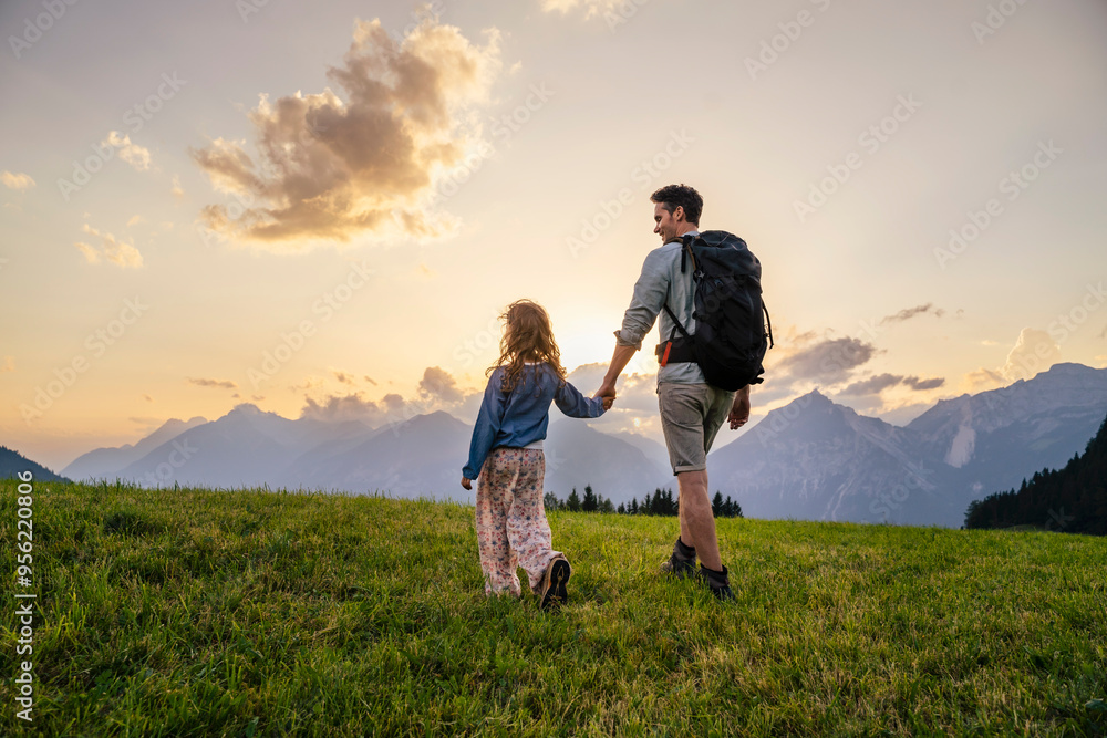 Father exploring with daughter in meadow at sunset Father exploring with daughter in meadow at sunset