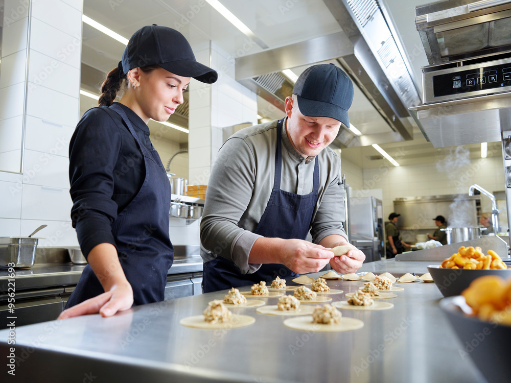 Chef teaching young trainee in restaurant Chef teaching young trainee in restaurant