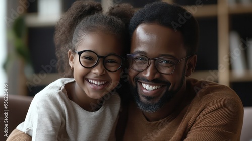 Father and daughter laughing during a video call, using technology to maintain a close bond despite physical distance.