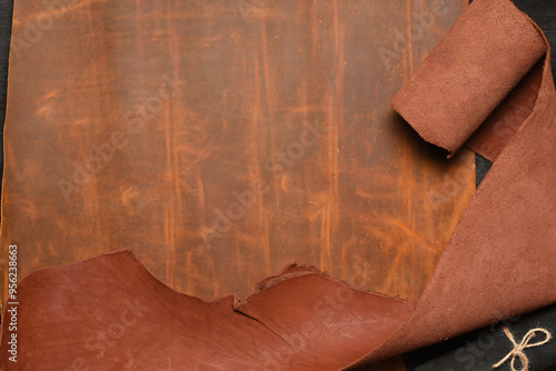 Brown leather rolled up pieces scrolls on the bown table background with copy space. Top view. photo