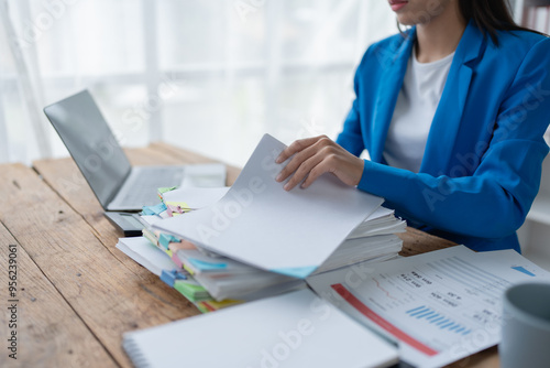 woman plans a finance and budget audit by reviewing organizing office financial documents