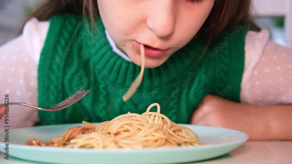 Portrait of girl having fun eating spaghetti. Child twists pasta on fork. Baby food concept. Portrait of girl having fun eating spaghetti. Child twists pasta on fork. Baby food concept.