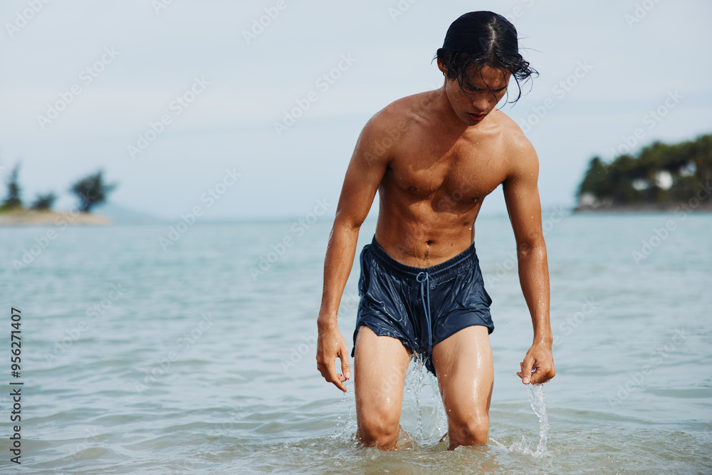 Active Asian Man Enjoying Tropical Vacation: Swimming, Smiling, and Having Fun in the Blue Ocean Active Asian Man Enjoying Tropical Vacation: Swimming, Smiling, and Having Fun in the Blue Ocean