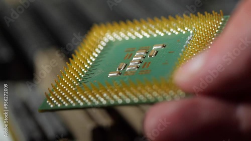 vintage computer microprocessor is held by a man's hand on a background of computer equipment