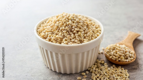 Barley rice in a white cup on gray cement background