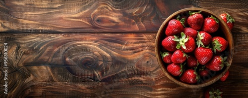 Beautifully arranged ripe strawberries in a rustic bowl on a wooden table, depicting healthy and natural food.