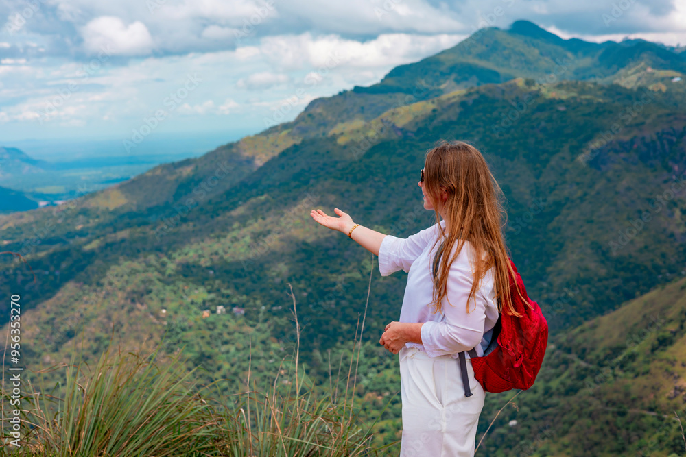 middle-aged woman with a backpack went hiking and admires picturesque and epic View from the Small Adam Peak Mountain in Sri Lanka middle-aged woman with a backpack went hiking and admires picturesque and epic View from the Small Adam Peak Mountain in Sri Lanka