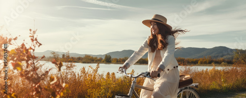 Woman riding bike at sunny day in field way. Rear view of girl riding bicycle.