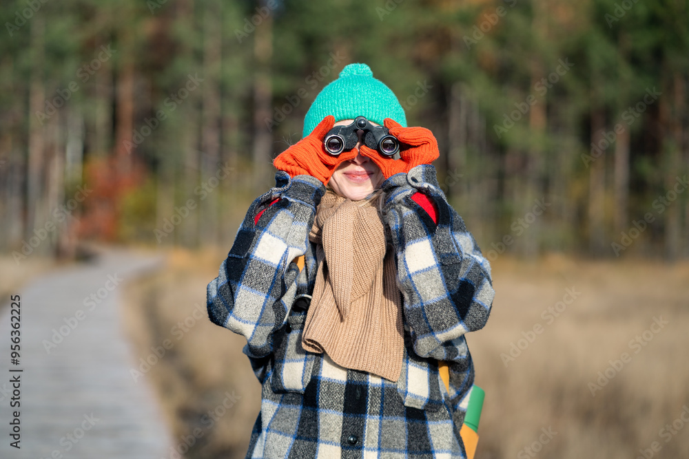 Curious woman using binoculars to observe birds, wildlife, landscape in autumn nature park. Female walking trail, monitoring, exploring nature, environmental conservation, biodiversity protection Curious woman using binoculars to observe birds, wildlife, landscape in autumn nature park. Female walking trail, monitoring, exploring nature, environmental conservation, biodiversity protection