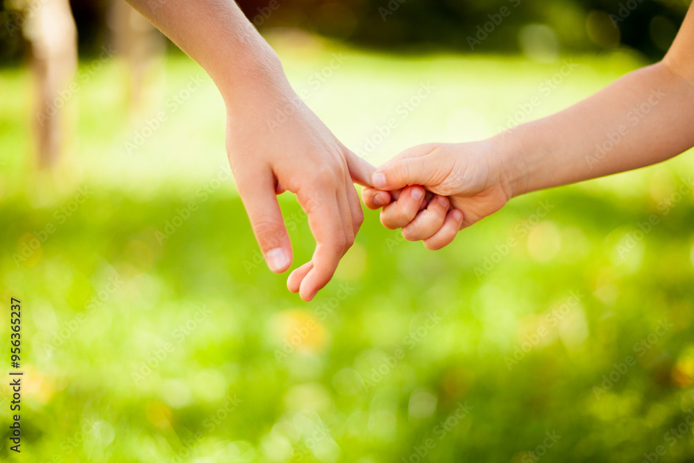 Small children holding hands, close up brother and sister. Not indoors on a sunny, summerday. Small children holding hands, close up brother and sister. Not indoors on a sunny, summerday.