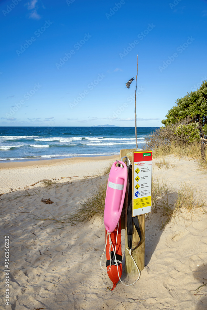 Red lifeguard float hanging on a post, Opoutere beach, New Zealand