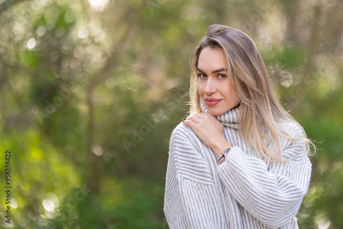 Beautiful blonde woman posing in a green forest