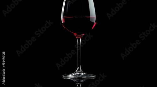 A glass of red wine on a black background.