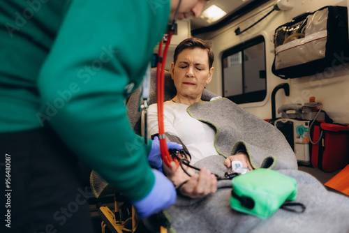 A woman's pulse is taken in an ambulance