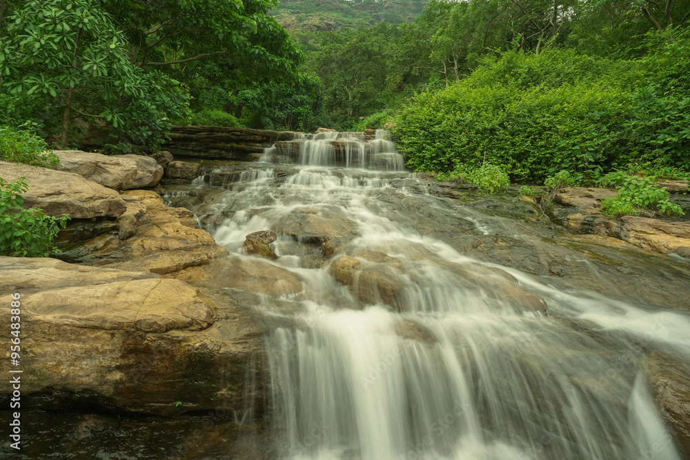 Long Exposure Silky Water Fall, Tranquil Waterfall Flowing Through Rocky Terrain, Cascading Waters in Lush Green Forest, Waterfall Surrounding Forest Environment, Serene Waterfall Stock Photo. Long Exposure Silky Water Fall, Tranquil Waterfall Flowing Through Rocky Terrain, Cascading Waters in Lush Green Forest, Waterfall Surrounding Forest Environment, Serene Waterfall Stock Photo.