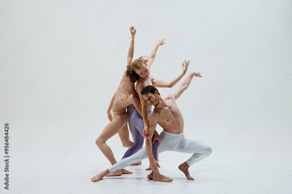 Obraz premium Dancers create intricate shape with fluid arm movements, demonstrating control and grace against white studio background. Concept of music and dance, modern and classical art, movement.