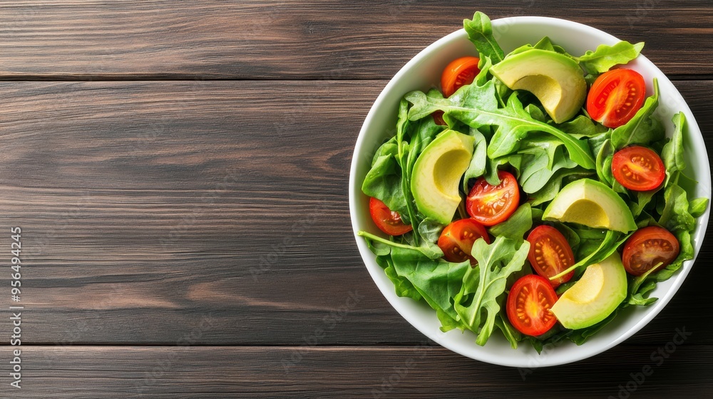 a vibrant bowl of mixed greens with avocado slices, cherry tomatoes, and a light vinaigrette dressing, arranged artfully on a rustic wooden table a vibrant bowl of mixed greens with avocado slices, cherry tomatoes, and a light vinaigrette dressing, arranged artfully on a rustic wooden table