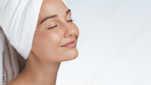 Serene Woman with Towel Wrapped Head Enjoying Relaxing Skincare Moment