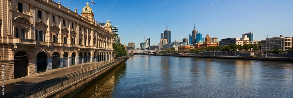 Naklejka premium A stunning cityscape captured from the riverside with historic buildings on one side and modern skyscrapers on the other, showcasing the blend of old and new architecture on a sunny day.