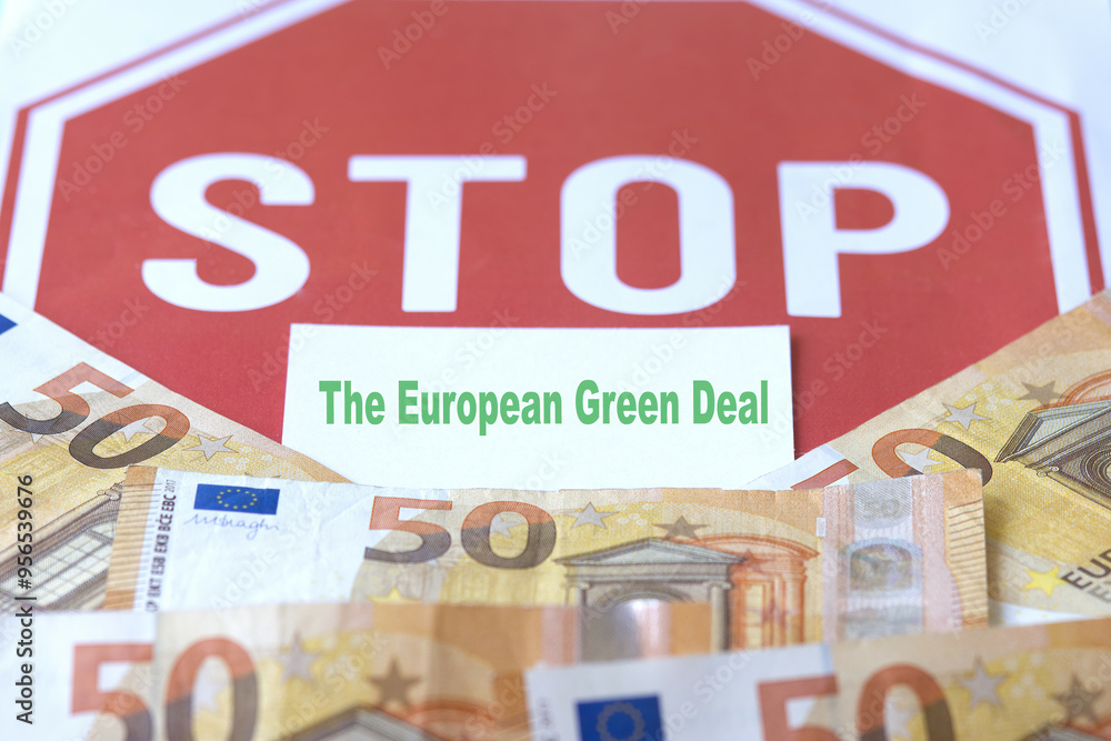 A business card with the words “The European Green Deal” in front of a STOP sign, with euro banknotes in the foreground, representing the concept of the cost of the Green Deal. A business card with the words “The European Green Deal” in front of a STOP sign, with euro banknotes in the foreground, representing the concept of the cost of the Green Deal.