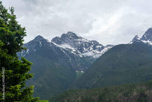 A stunning North Cascades mountain view on a cloudy day with a lot of greenery.