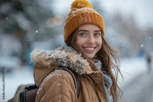 A wide-angle view captures vibrant winter landscape as a smiling girl, adorned in a cozy winter coat and carrying luggage, eagerly embarks on a travel adventure, her excitement palpable against backdr photo