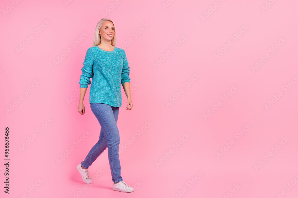 Full size photo woman smiling go make step wearing stylish outfit isolated pink color background Full size photo woman smiling go make step wearing stylish outfit isolated pink color background