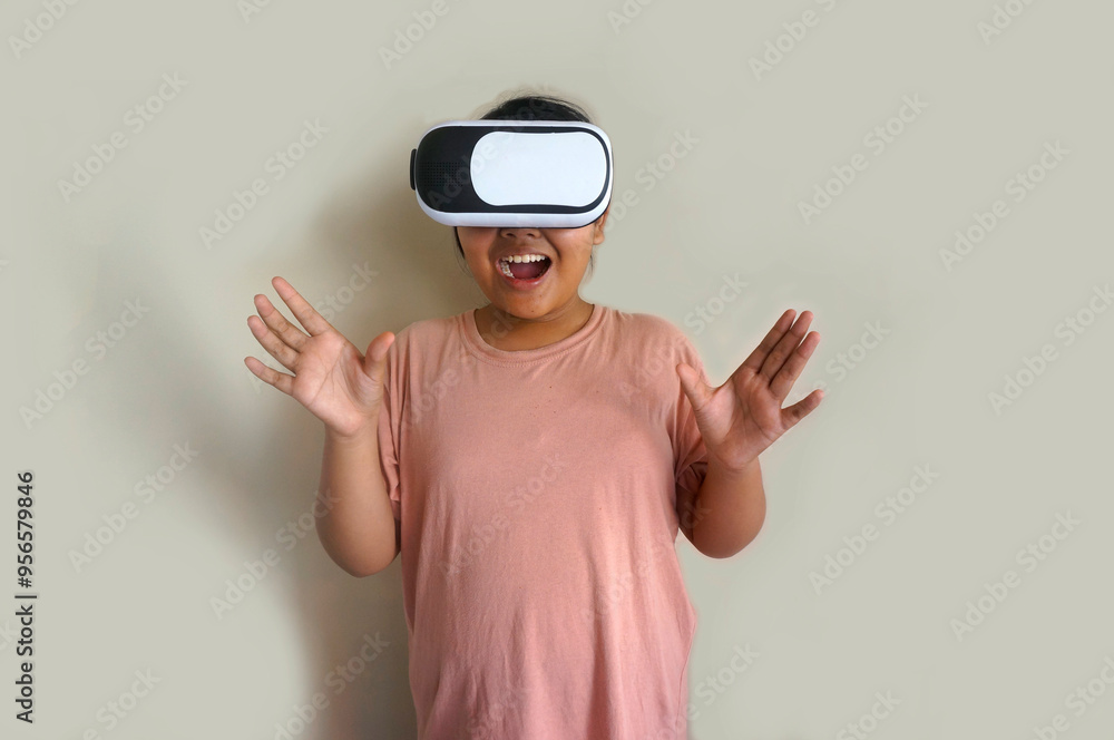 Excited Asian Fat Little Girl Wearing VR Glasses, Isolated On Beige Background Excited Asian Fat Little Girl Wearing VR Glasses, Isolated On Beige Background