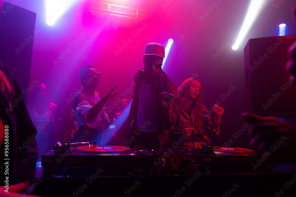 Obraz premium Still footage of a group of young people dancing and jumping while DJ playing the beats