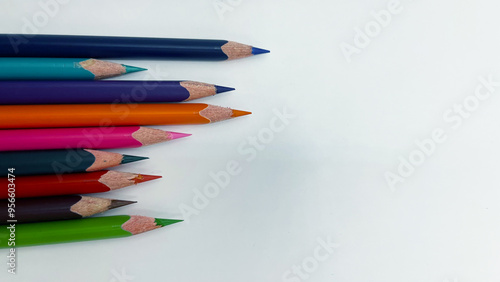 Colorful sharpened pencils are lined up on the table.