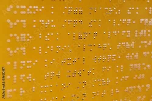 Close up view of text in braille code on yellow metal plate