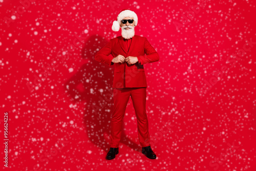 Full length photo of attractive happy positive old man wear tuxedo santa claus isolated on red color background