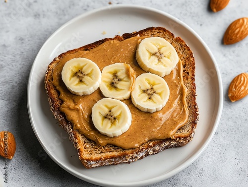 A delicious slice of whole grain toast topped with almond butter and fresh banana slices, perfect for a nutritious breakfast. photo