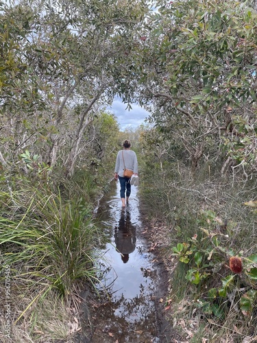фотографія artistic symmetrical image of woman walking in Australian bushland wetlands
