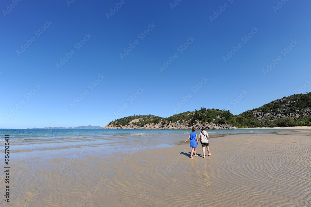 Two women walking on the beautiful sandy beach at Florence Bay, Magnetic Island, QLD, Australia Two women walking on the beautiful sandy beach at Florence Bay, Magnetic Island, QLD, Australia