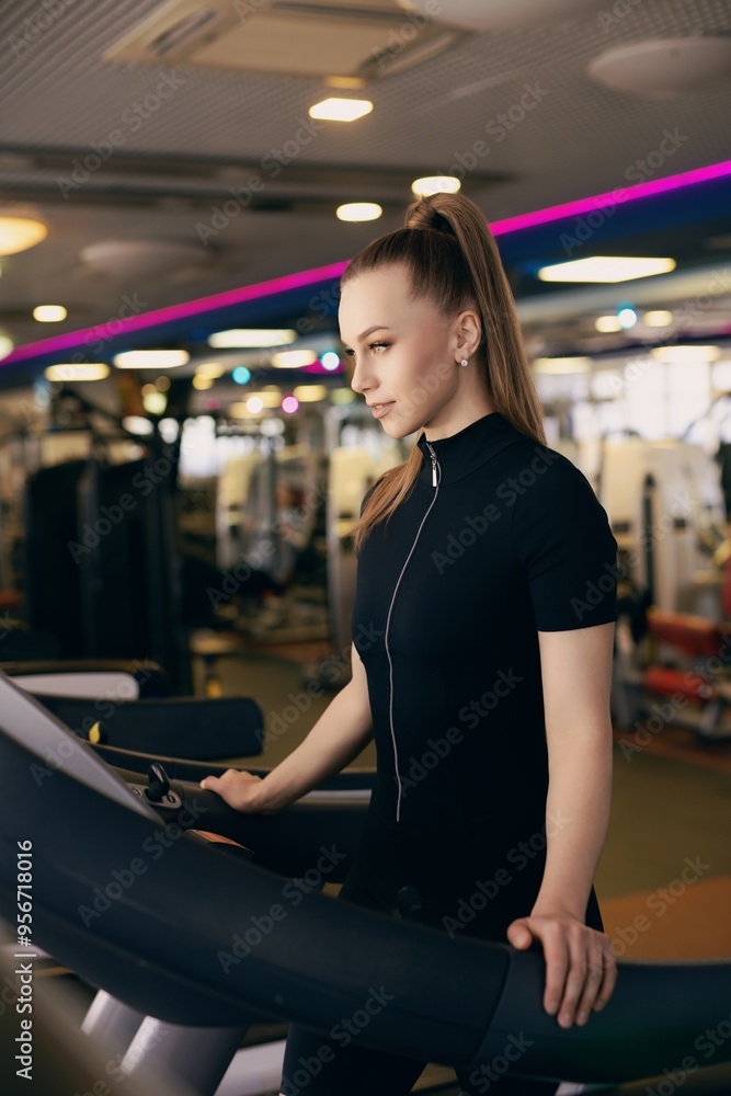 Young woman exercising on a treadmill in a modern gym during daytime Young woman exercising on a treadmill in a modern gym during daytime