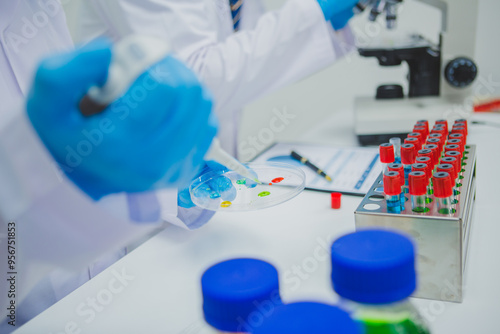 In this chemical experiment, two researchers collaborate to mix reactants, carefully observe changes such as color shifts or gas production, and analyze results, demonstrating principles of chemistry