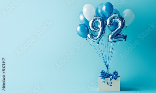 Happy birthday 92th with blue foil balloons and gift box on color background photo