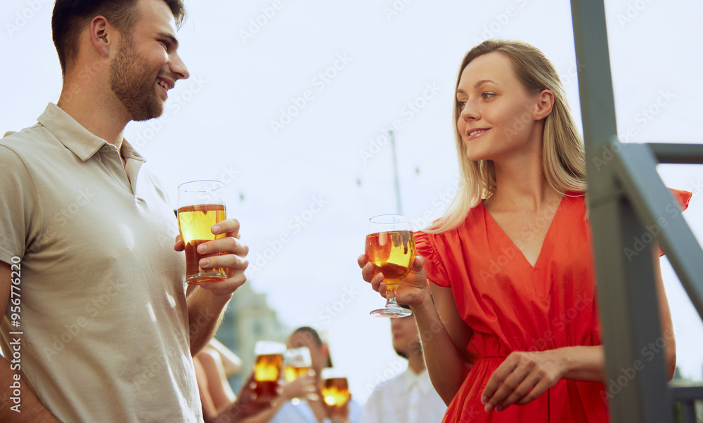 Man and woman enjoy beautiful sunny day, talking and relaxing, drinking beer on sunlit terrace. Festive atmosphere. Concept of Friday mood, celebration, lunch break and Oktoberfest. Man and woman enjoy beautiful sunny day, talking and relaxing, drinking beer on sunlit terrace. Festive atmosphere. Concept of Friday mood, celebration, lunch break and Oktoberfest.