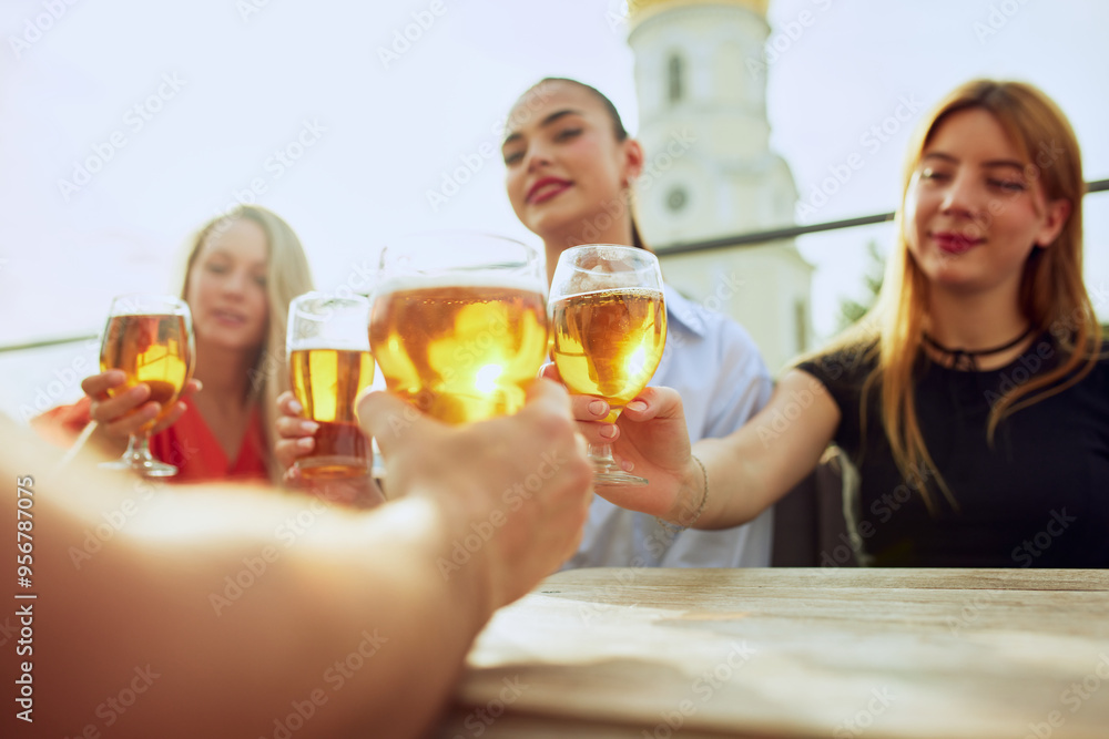 Surrounded by friends, woman in white shares heartfelt toast, as everyone joins in celebration, creating memories over drinks and conversation. Concept of Friday mood, celebration, Oktoberfest. Surrounded by friends, woman in white shares heartfelt toast, as everyone joins in celebration, creating memories over drinks and conversation. Concept of Friday mood, celebration, Oktoberfest.