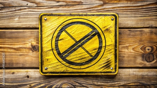 A bright yellow warning sign with a bold, hand-drawn doodle of a prohibited symbol, placed on a rough, textured wood background, conveying a sense of creative restriction. photo