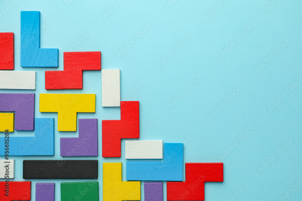 Obraz premium Colorful wooden puzzle pieces on light blue background, top view. Space for text