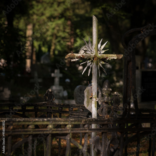 
CEMETERY - An old steel cross on a tombstone photo